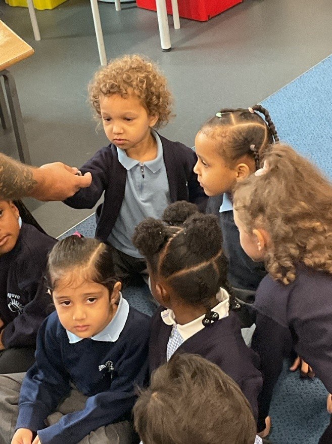 Nursery children petting snails being held by keeper