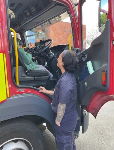 Nursey children taking turns sitting in the fire engine's drivers seat