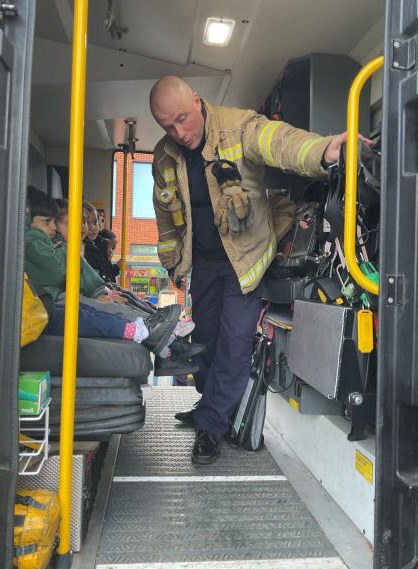 Children getting a talk from the fire engine staff