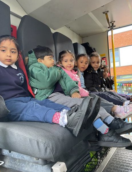 A group of nursey children sitting in the back of the fire engine